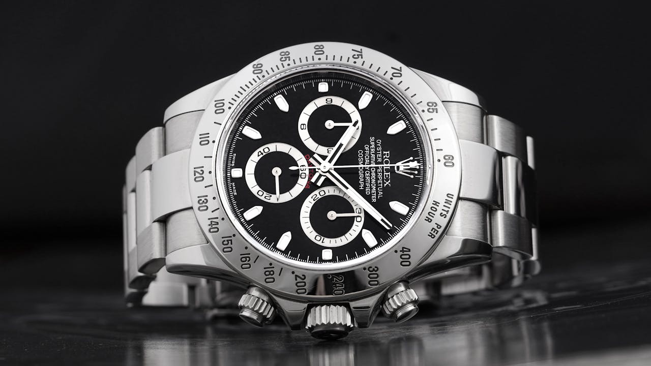 Close-up of a luxury silver chronograph wristwatch on a dark background, showcasing elegance and precision.